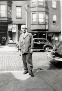 Dressed for work, Lazarus stands on the sidewalk in front of the family's store, ca. 1950. Courtesy of Angelo Kontis.